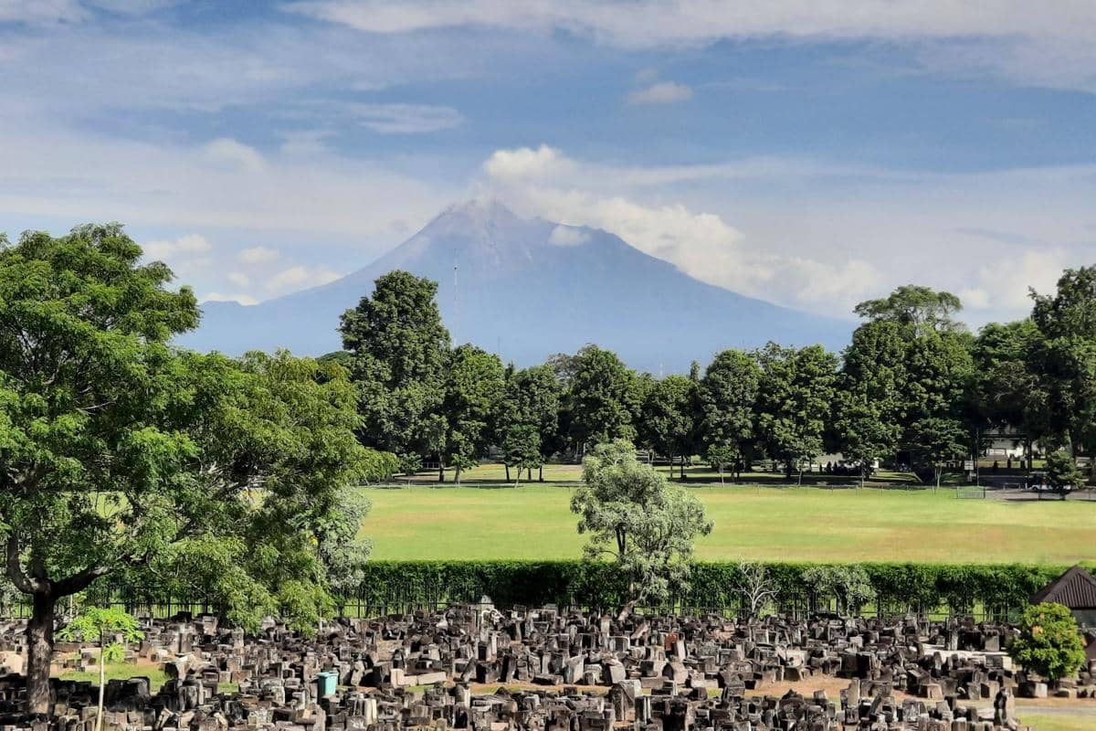 Reruntuhan Candi Perwara di Kompleks Candi Prambanan berlatar Gunung Merapi 