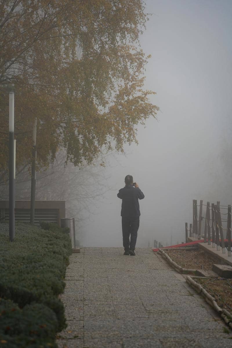 Pria yang berjalan sendiri di tengah kabut perkotaaan