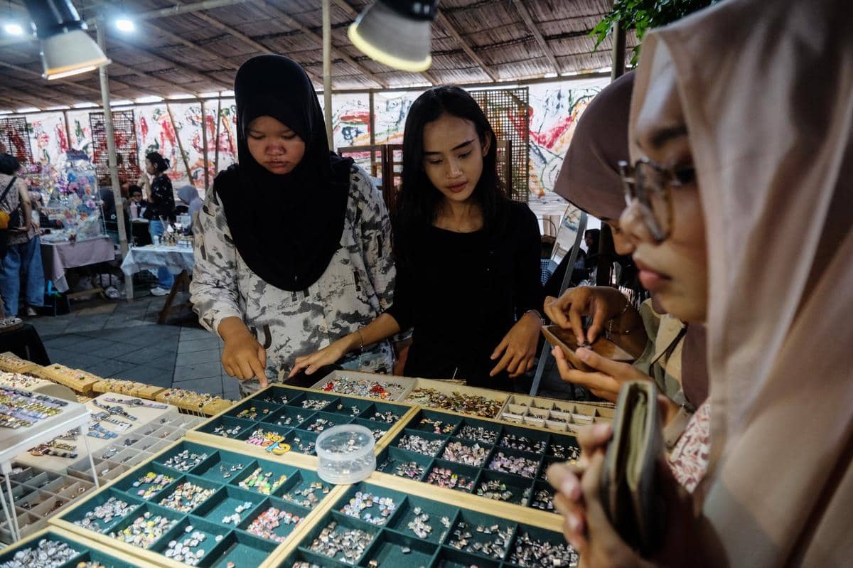 Pengunjung memilih produk kerajinan seni yang dipasarkan saat Solo Art Market di kawasan wisata Ngarsopuro Solo, Jawa Tengah, Solo, Jawa Tengah, Kamis (1/1/2026). (ANTARA FOTO/Maulana Surya)