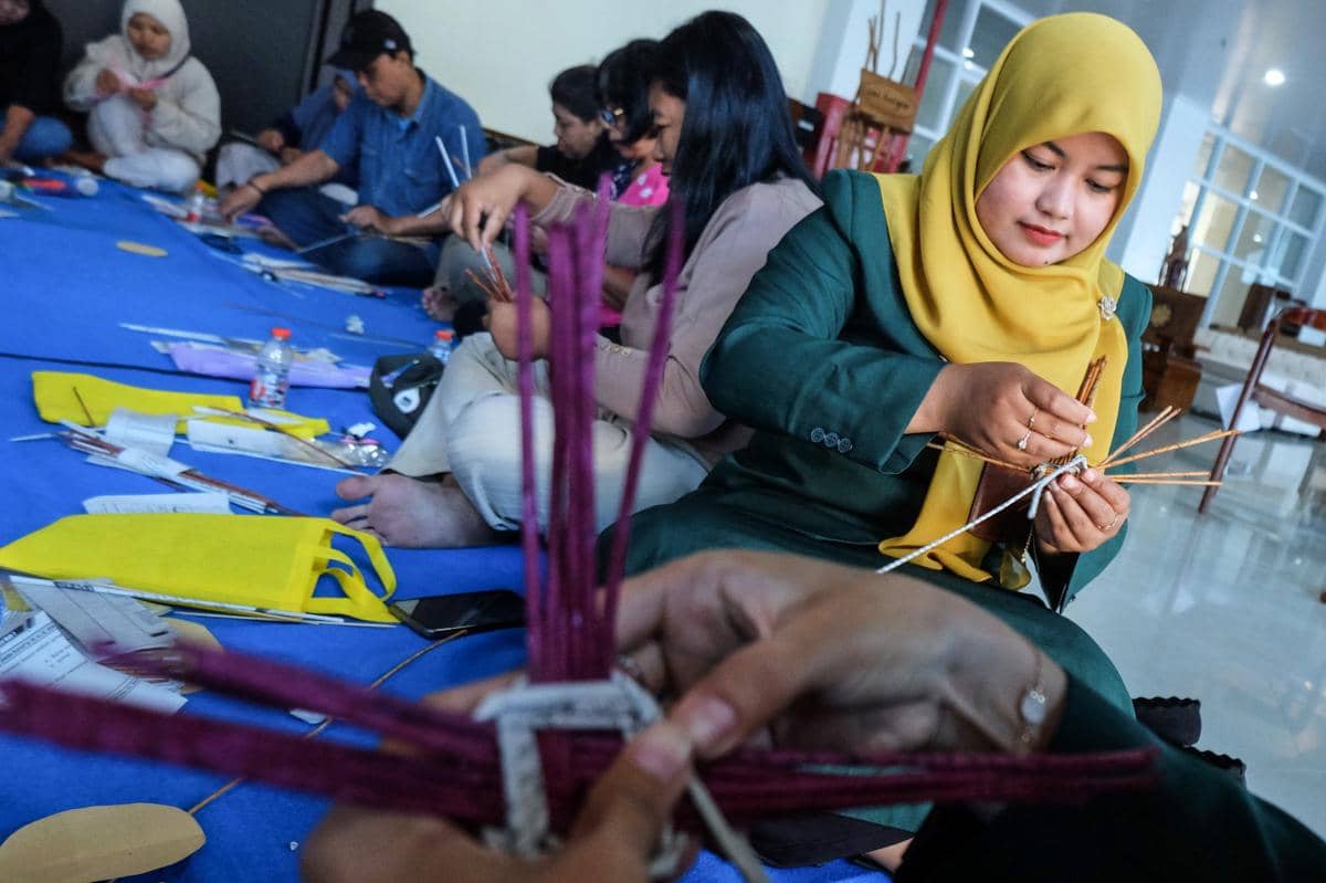 Peserta membuat suvenir anyaman kertas bekas saat pelatihan singkat di Sentra IKM Srikayu, Solo, Jawa Tengah, Senin (29/12/2025). (ANTARA FOTO/Maulana Surya)