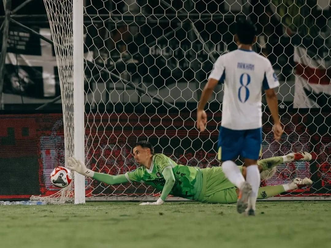 Mike Hauptmeijer (hijau) saat menghalau tendangan pemain Arema FC (putih). 