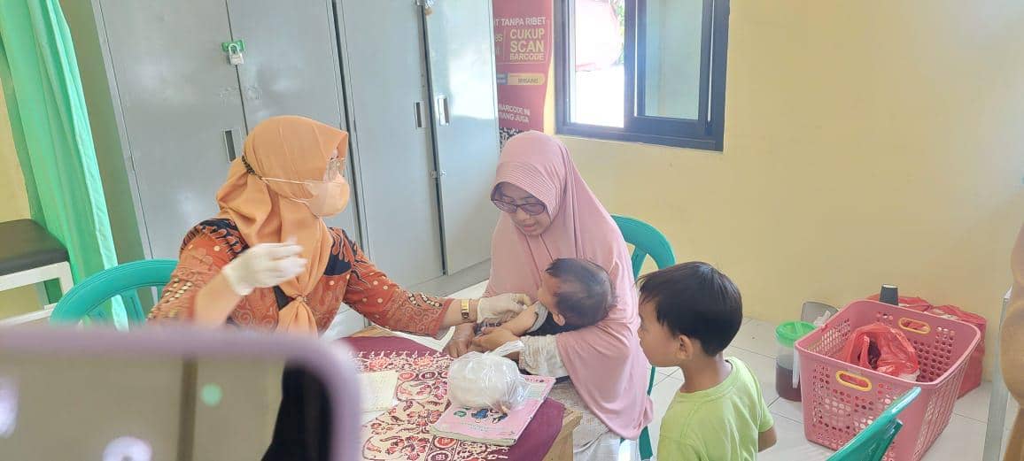 balita sedang di imunisasi oleh bidan