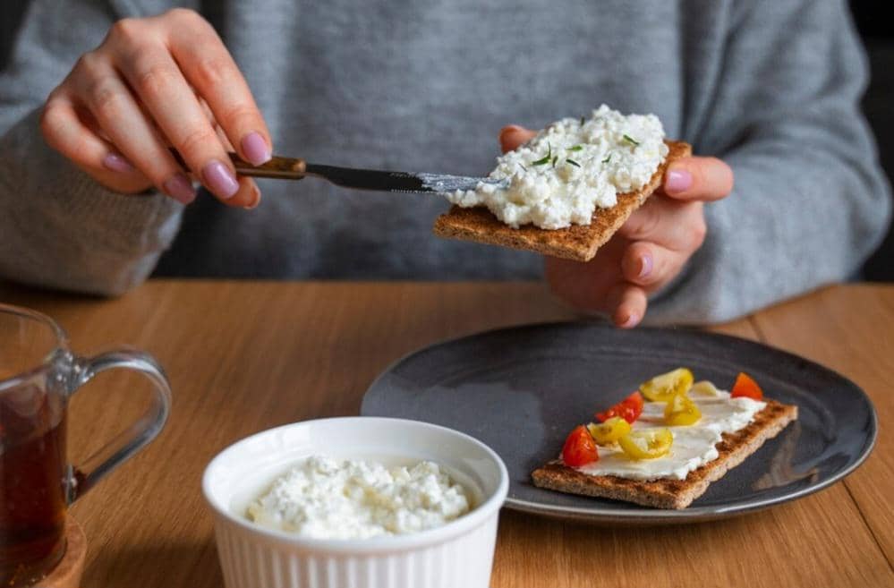 mengoleskan cottage cheese pada roti panggang (freepik.com/freepik)