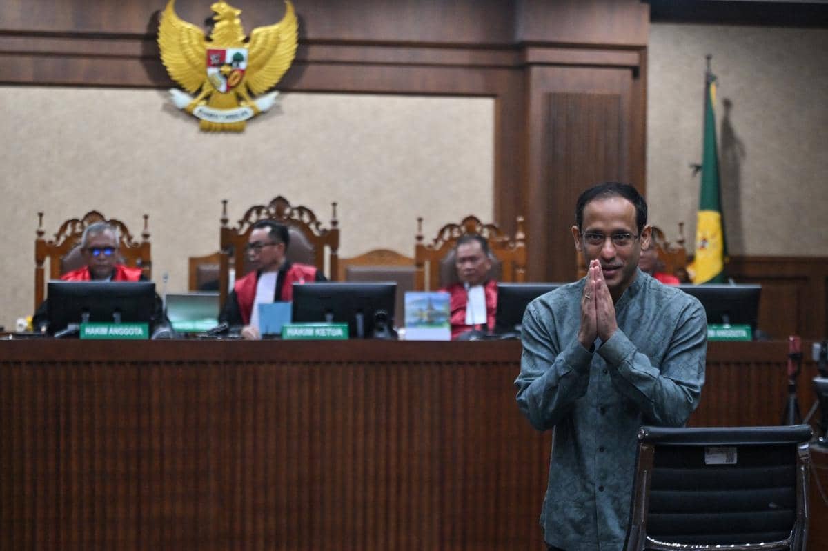 Tersangka kasus dugaan korupsi dalam digitalisasi pendidikan pengadaan laptop Chromebook di Kemendikbudristek tahun 2019-2022 Nadiem Makarim (kanan) memberikan salam ke arah wartawan sebelum sidang pembacaan dakwaan di Pengadilan Tipikor, Jakarta, Senin (5/1/2026). (ANTARA FOTO/Bayu Pratama S)