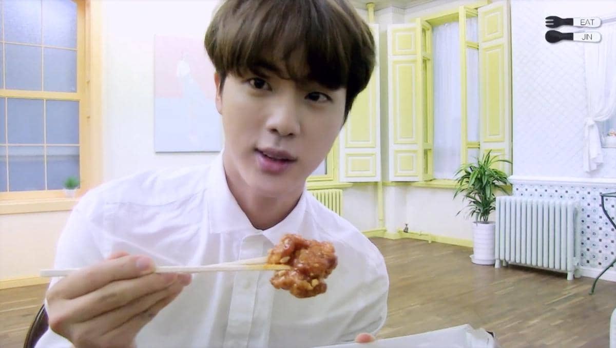 Jin BTS memperlihatkan hidangan yang dimakannya berupa beberapa jenis olahan ayam serta pizza dalam konten EAT JIN