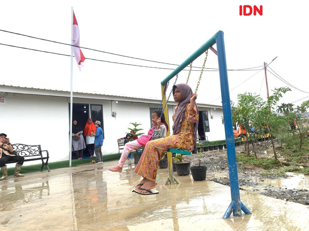 Anak-anak bermain ayunan di hunian sementara yang dibangun Danantara di Aceh Tamiang, Kamis (8/1/2026) (IDN Times/Doni Hermawan)