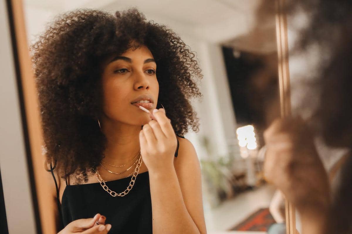 ilustrasi wanita sedang memoles lipstik