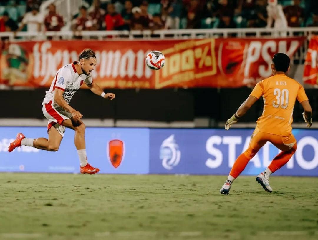 Thijmen Goppel (putih) berusaha melewati hadangan kiper PSM Makassar. 