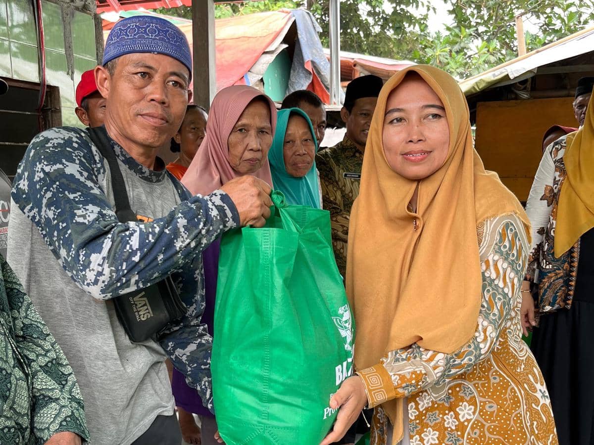 Kepala KUA Kecamatan Mijen, Zahrotun Nisa (kanan) memberikan bantuan kepada pemulung di TPA Jatibarang Semarang. (Dok. KUA Mijen)