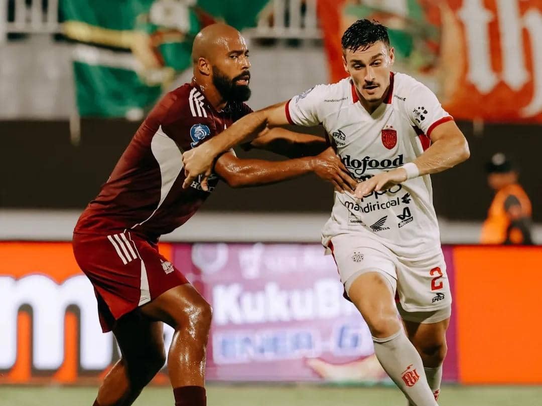 Pemain Bali United (putih) mendapatkan pengawalan dari pemain PSM Makassar (merah)