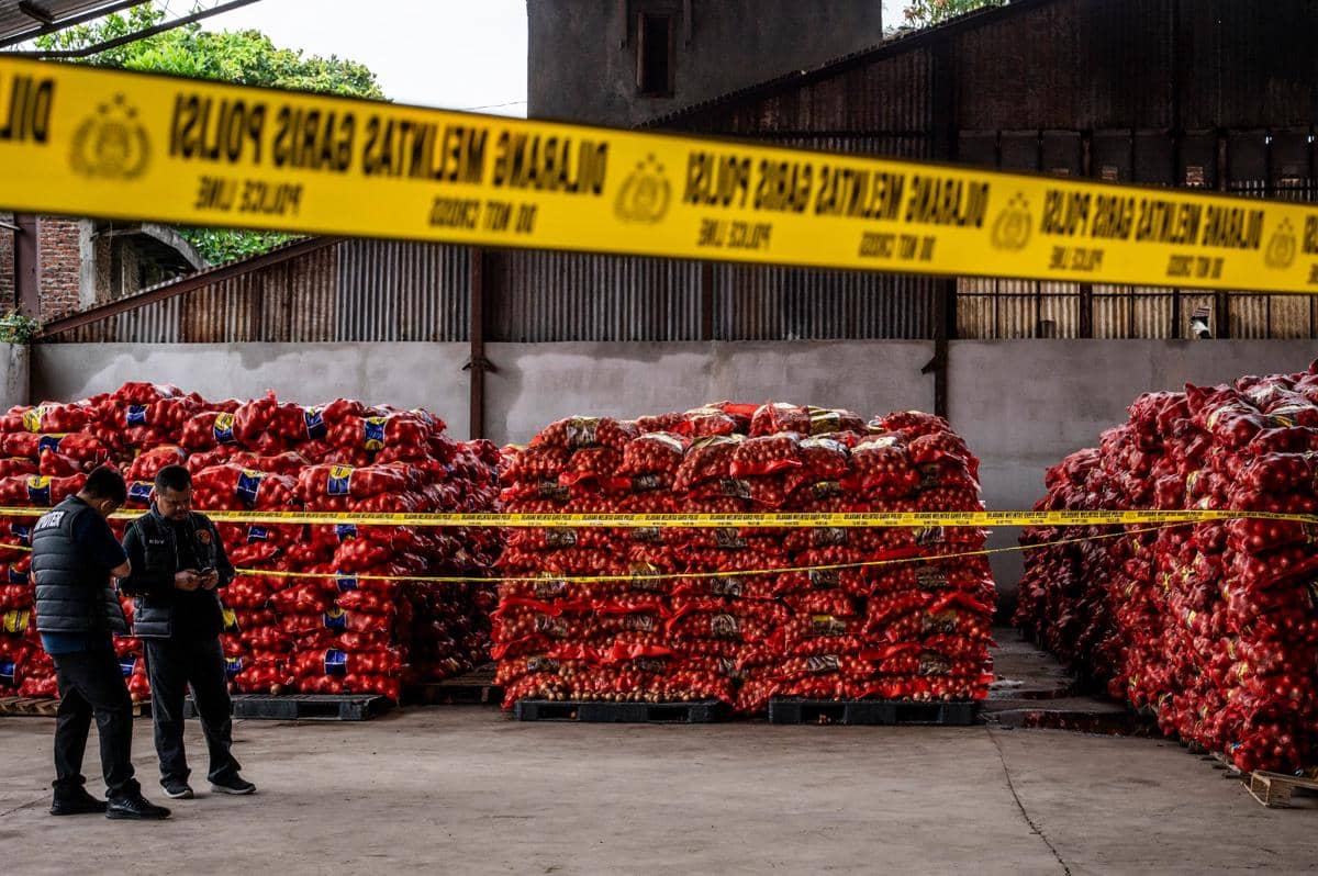Petugas Dirtipidter Bareskrim Polri berdiri di dekat barang bukti bawang bombai ilegal di Kompleks Pergudangan Bandarharjo, Semarang, Jawa Tengah, Sabtu (10/1/2026). (ANTARA FOTO/Aprillio Akbar)