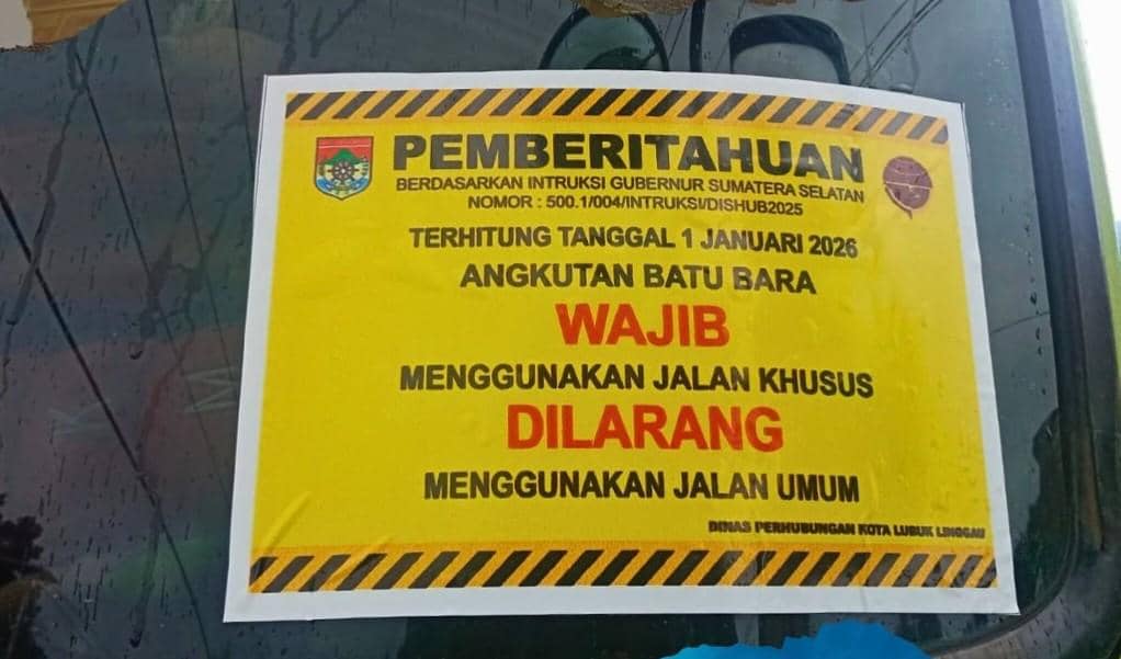 Petugas memasang stiker di truk batubara.