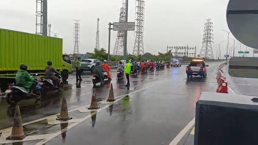 Pemotor di Bekasi dikawal polisi saat terjadi banjir. (Istimewa)