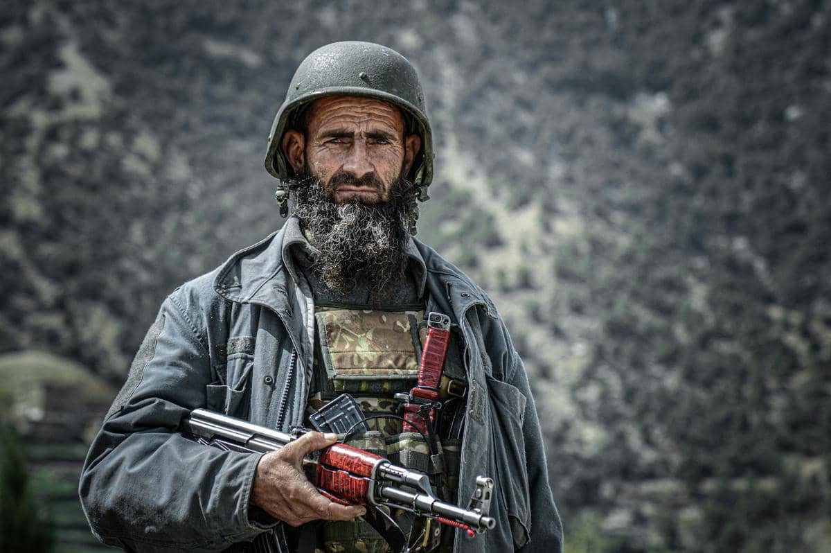 Seorang kakek sedang memegang senjata.