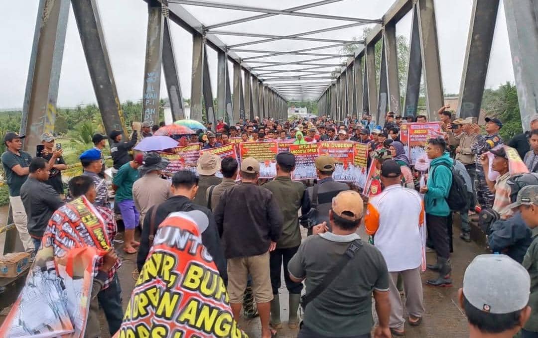 Warga Lalan saat protes membentangkan spanduk terkait penutupan jembatan P6 untuk dilewati angkutan batubara.