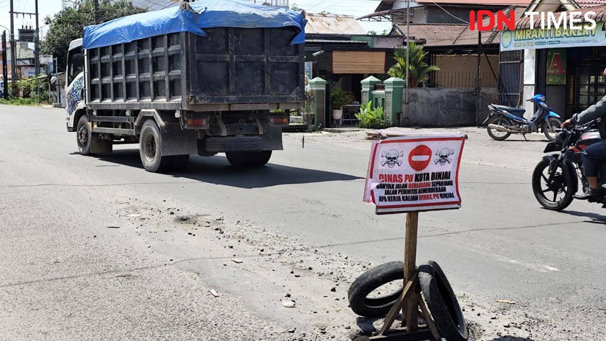 Bentuk protes atas jalan rusak, warga Binjai tuangkan dengan pasang plang dijalan berlubang (IDN Times/ Bambang Suhandoko)