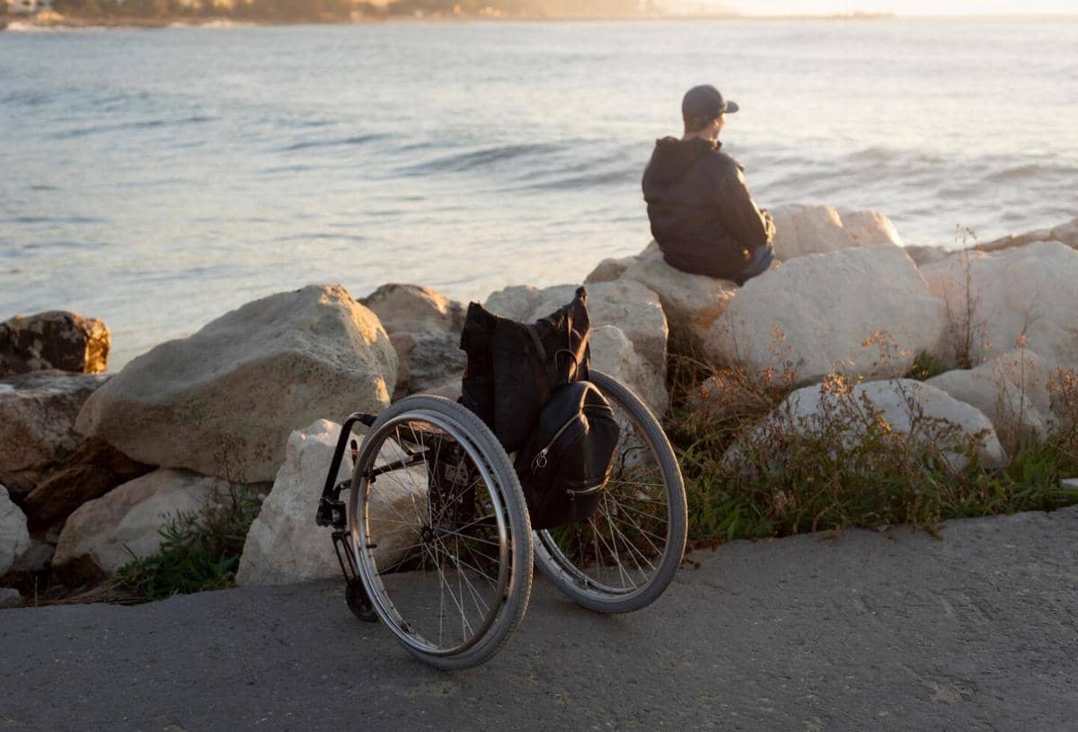 ilustrasi laki-laki disabilitas di pinggir pantai