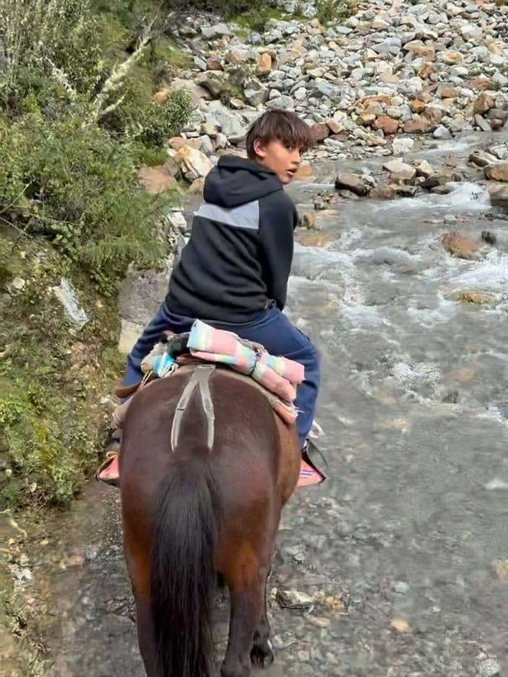 Keluarga Indah Kalalo berkuda di tepi Danau Humantay