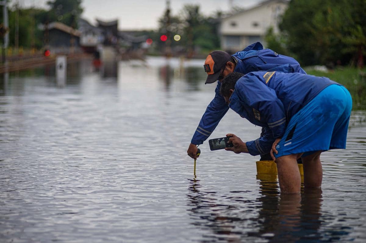 Petugas mengukur ketinggian air yang merendam jalur rel kereta api di sekitar Stasiun Pekalongan, Kota Pekalongan, Jawa Tengah, Sabtu (17/1/2026). (ANTARA FOTO/Harviyan Perdana Putra)