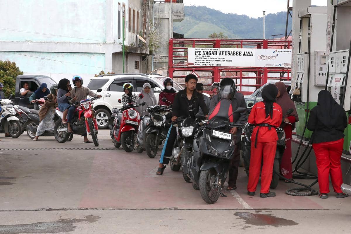 Ilustrasi petugas SPBU (kanan) melayani warga yang mengisi bahan bakar untuk kendaraan. (ANTARA FOTO/Irwansyah Putra)