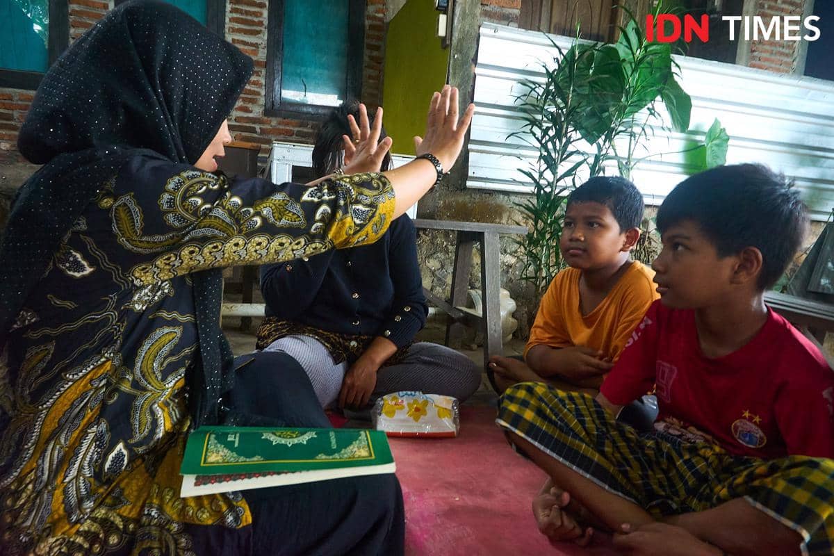 Penyuluh Agama Islam KUA Mijen, Zahrotun Nisa (kiri) mengajarkan tata cara Tayamum kepada Ernawati (kedua kiri), dan kedua anaknya, Arthur (tengah) dan Marco (kanan), yang difabel di Semarang, Kamis (15/1/2026). (IDN Times/Dhana Kencana)