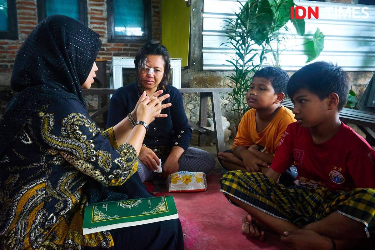 Penyuluh Agama Islam KUA Mijen, Zahrotun Nisa (kiri) mengajarkan tata cara Tayamum kepada Ernawati (kedua kiri), dan kedua anaknya, Arthur (tengah) dan Marco (kanan), yang difabel di Semarang, Kamis (15/1/2026). (IDN Times/Dhana Kencana)
