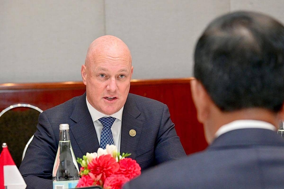 Perdana Menteri Selandia Baru, Christopher Luxon, sedang berbicara dengan mantan Presiden Indonesia, Joko Widodo.