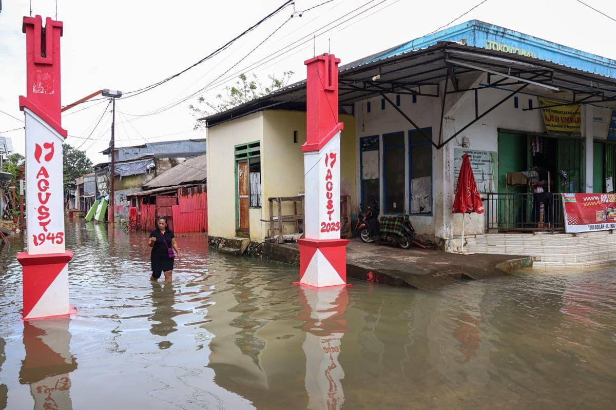 Warga menerobos banjir yang merendam area permukiman di Keluraham Katimbang, Makassar, Sulawesi Selatan, Senin (12/1/2026). (FOTO/Arnas Padda)