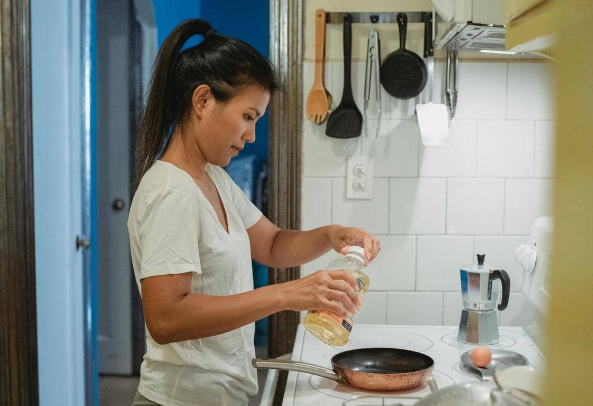 ilustrasi menuangkan minyak di atas wajan