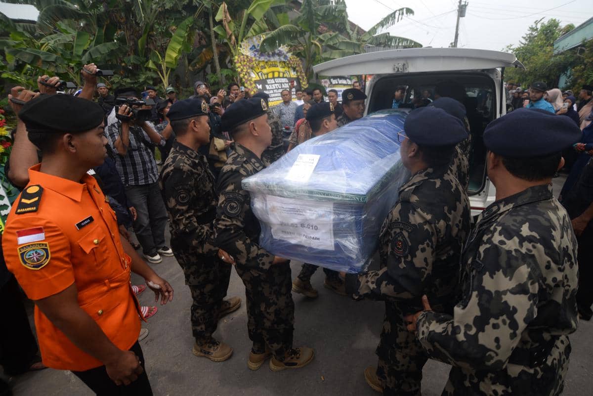 Petugas Kementerian Kelautan dan Perikanan (KKP) mengeluarkan peti jenazah korban kecelakaan pesawat ATR 42-500, almarhum Restu Adi Pribadi saat tiba di rumah duka, Wonosari, Klaten, Jawa Tengah, Minggu (25/1/2026). (ANTARA FOTO/Aloysius Jarot Nugroho)