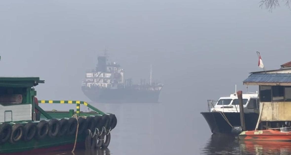 Kapal di Sungai Kapuas terhalang kabut asap. 