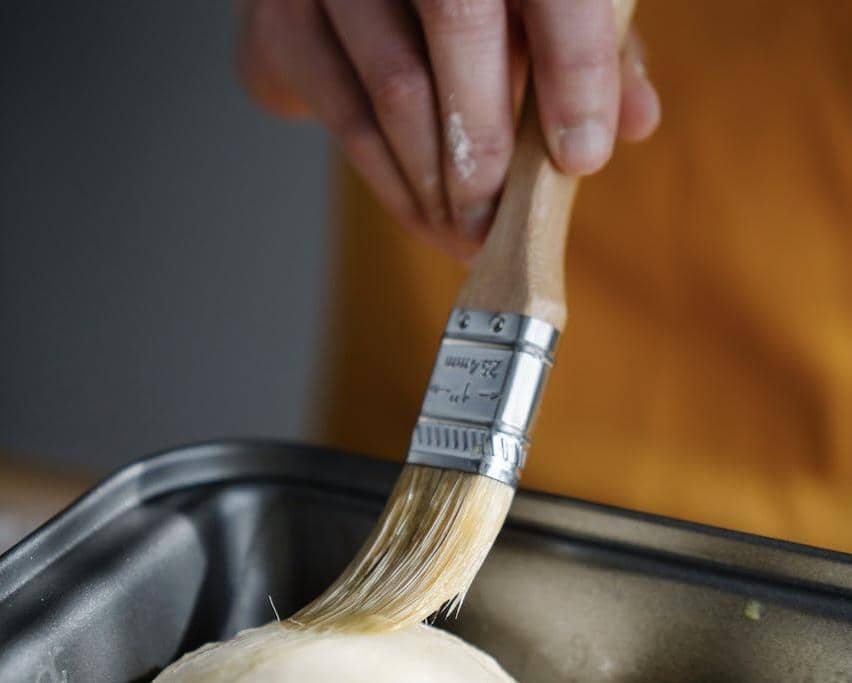 Potret mengoles kuning telur di atas roti 