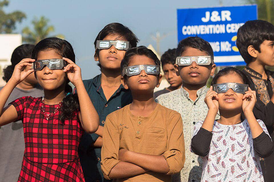 anak-anak melihat gerhana matahari dengan kacamata khusus