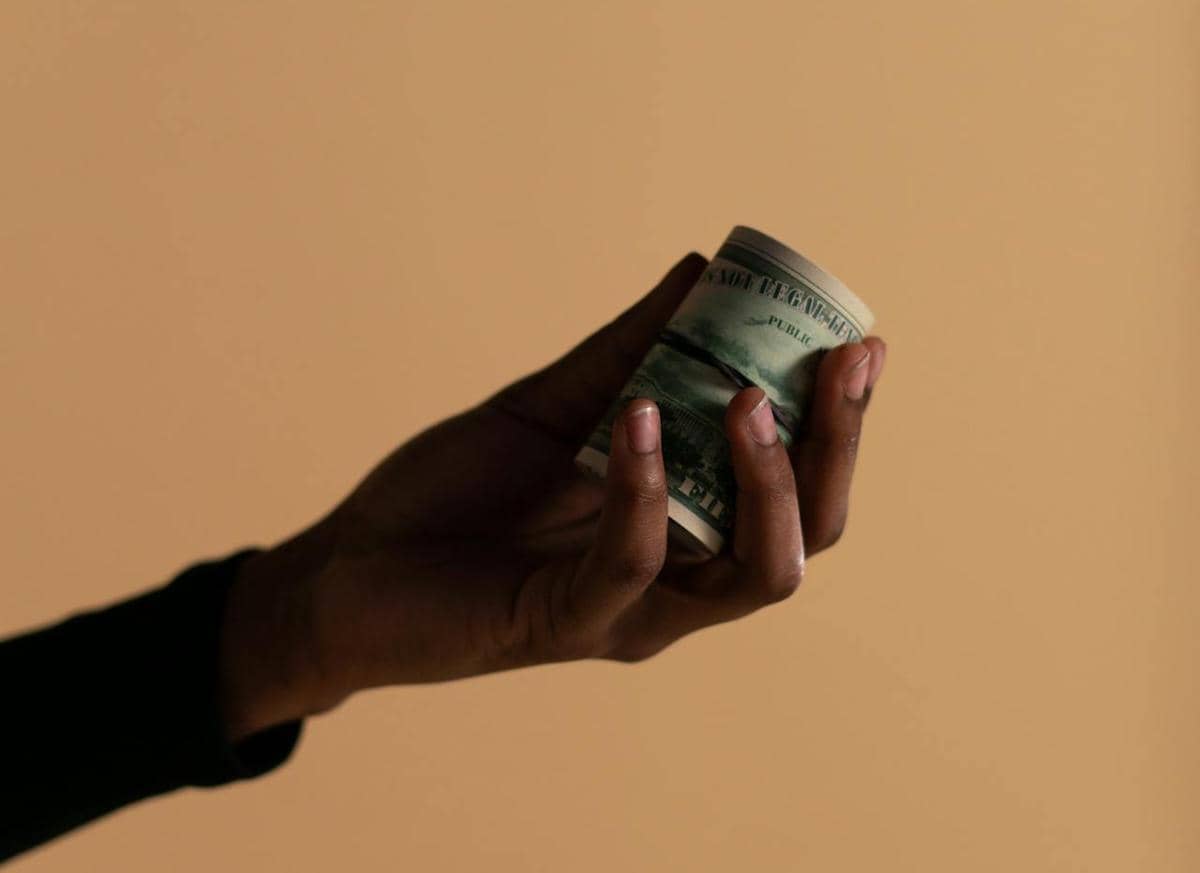 Seseorang sedang memberi sejumlah uang.