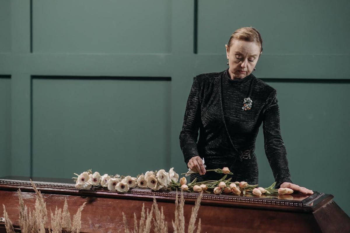 ilustrasi wanita berdiri di samping peti mati