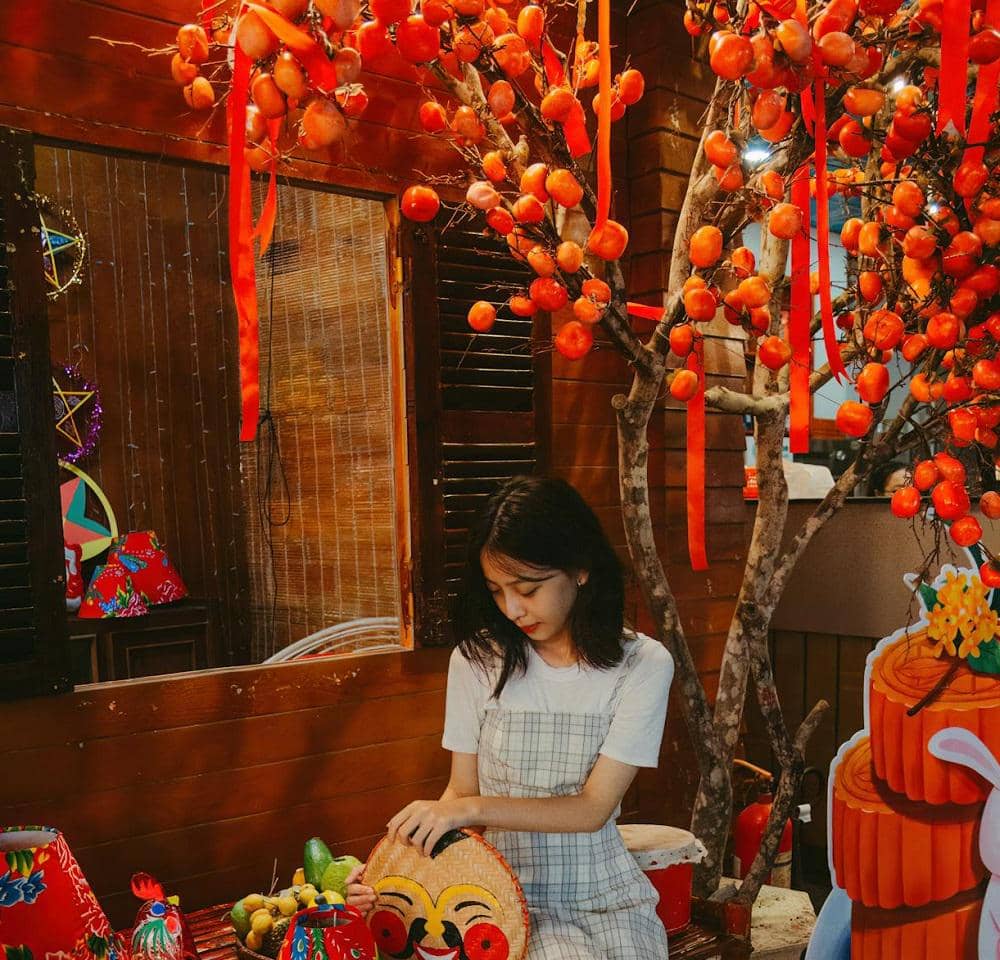 ilustrasi pohon mei hwa dengan hiasan pita kaligrafi merah dan buah jeruk 