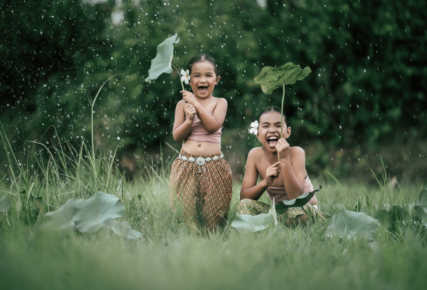 dua anak kecil bermain hujan