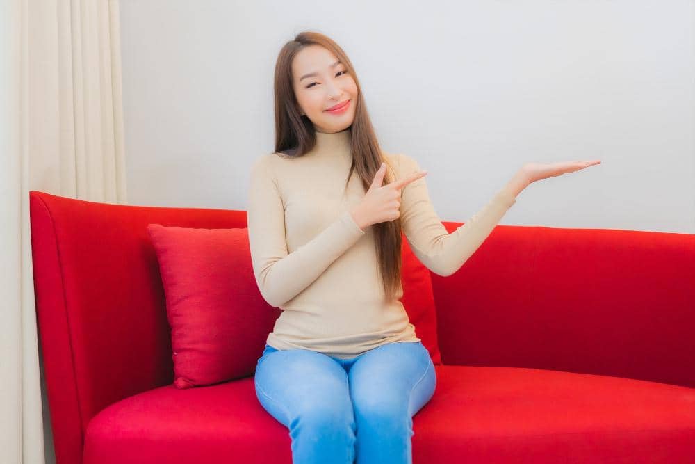 ilustrasi perempuan duduk di sofa merah