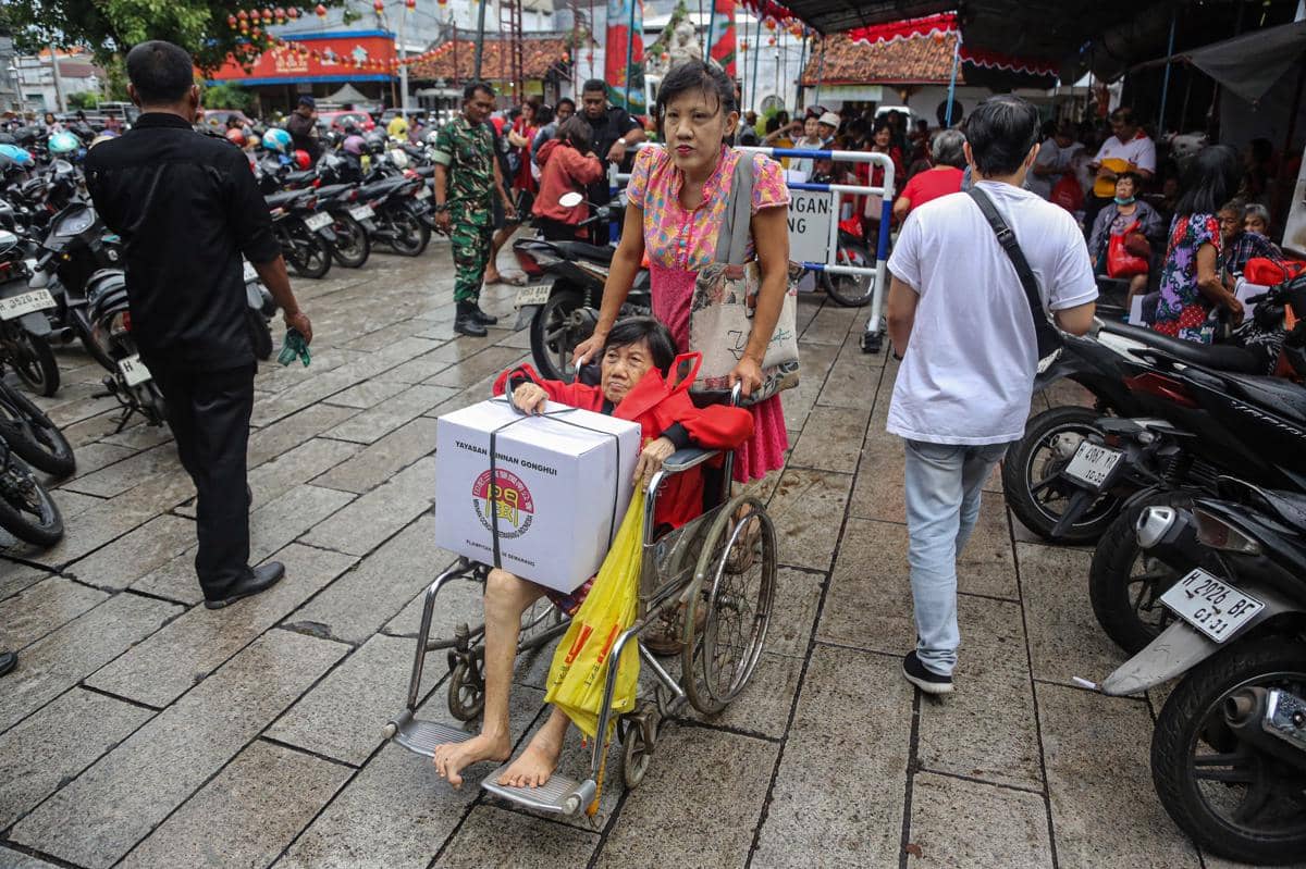 Sejumlah warga lanjut usia (lansia) membawa paket sembako usai dibagikan gratis dalam tradisi pembagian angpau di Klenteng Besar TITD Tay Kak Sie, Semarang, Jawa Tengah, Minggu (1/2/2026). (ANTARA FOTO/Makna Zaezar)