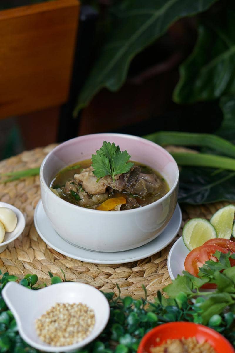 Vegetables Beside Soup in White Bowl on Wicker Surface
