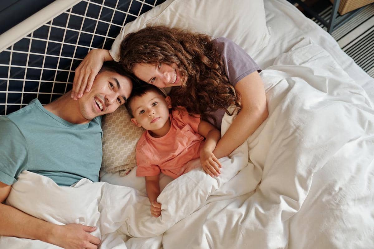 Seorang anak kecil sedang bermain bersama orang tuanya.