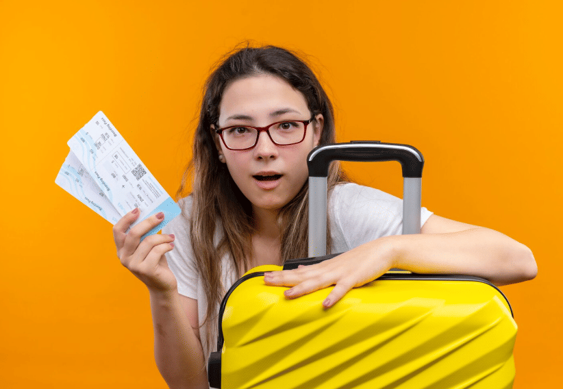 traveler memegang tiket pesawat dan koper