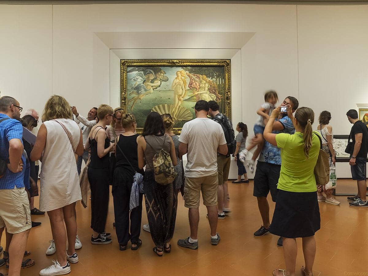 Momen orang-orang yang sedang melihat lukisan ikonik Sandro Botticelli, The Birth of Venus , di Galeri Uffizi di Florence, Italia. 