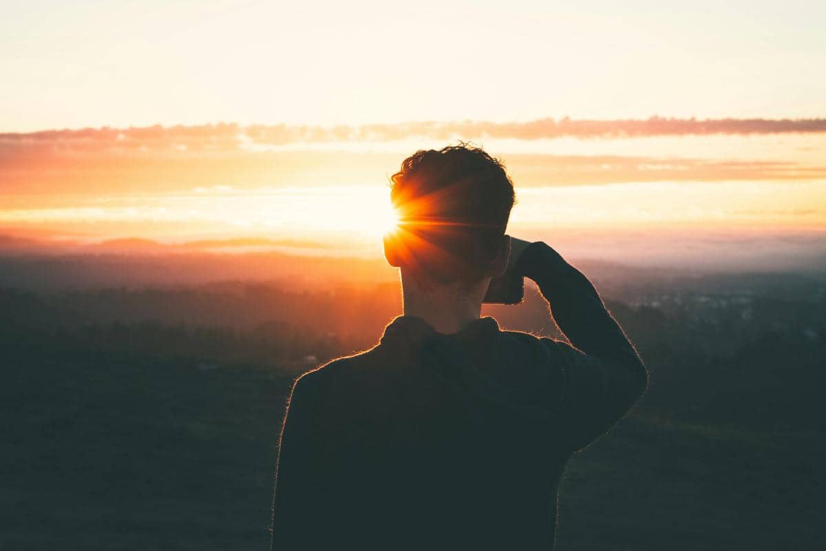 ilustrasi orang memotret matahari terbit