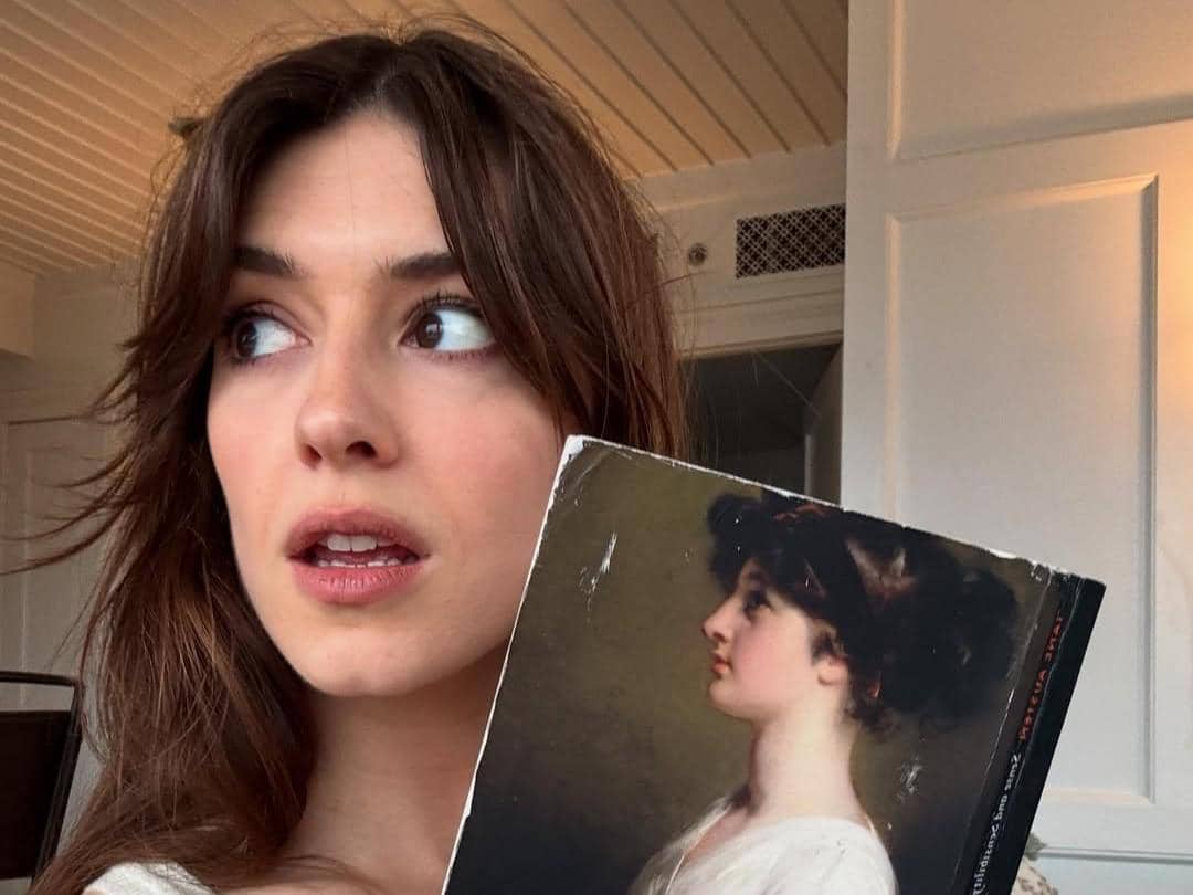 Daisy Edgar Jones memegang buku Sense and Sensibility