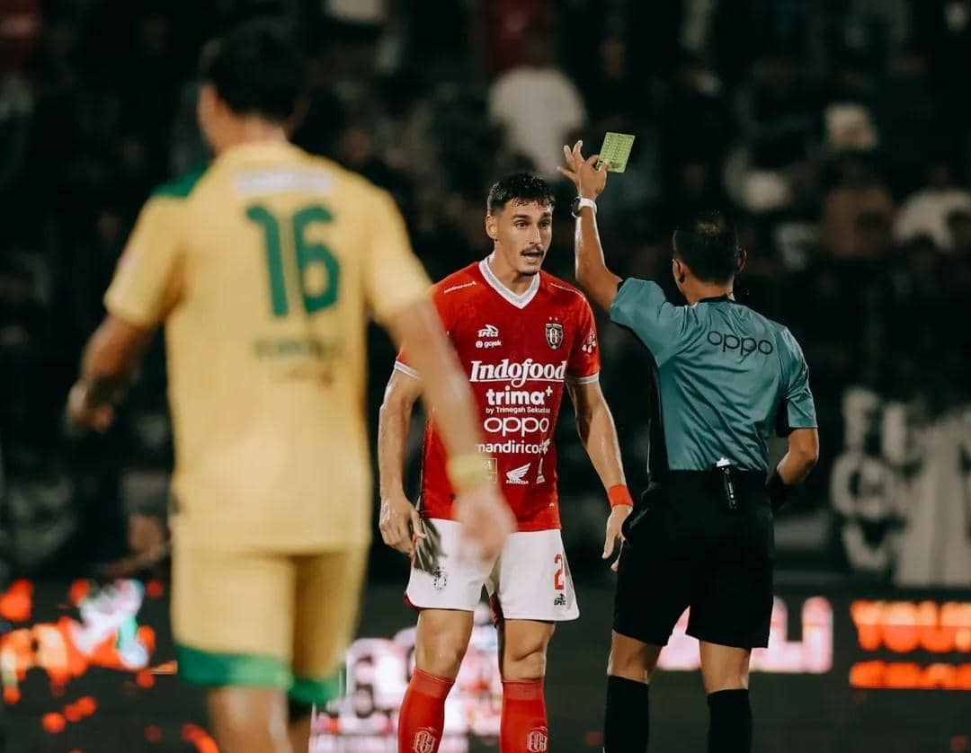 Joao Ferrari (merah) saat mendapatkan hukuman kartu kuning. 