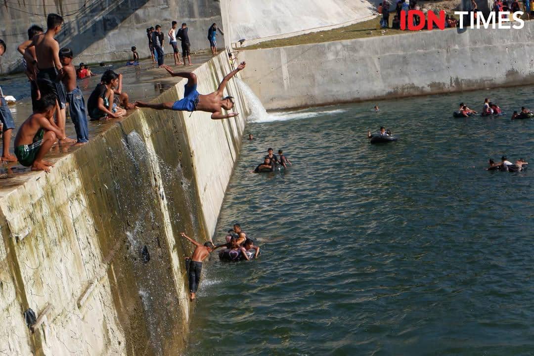 Warga di Padang mandi di salah satu bendungan yang ada di Kecamatan Koto Tangah