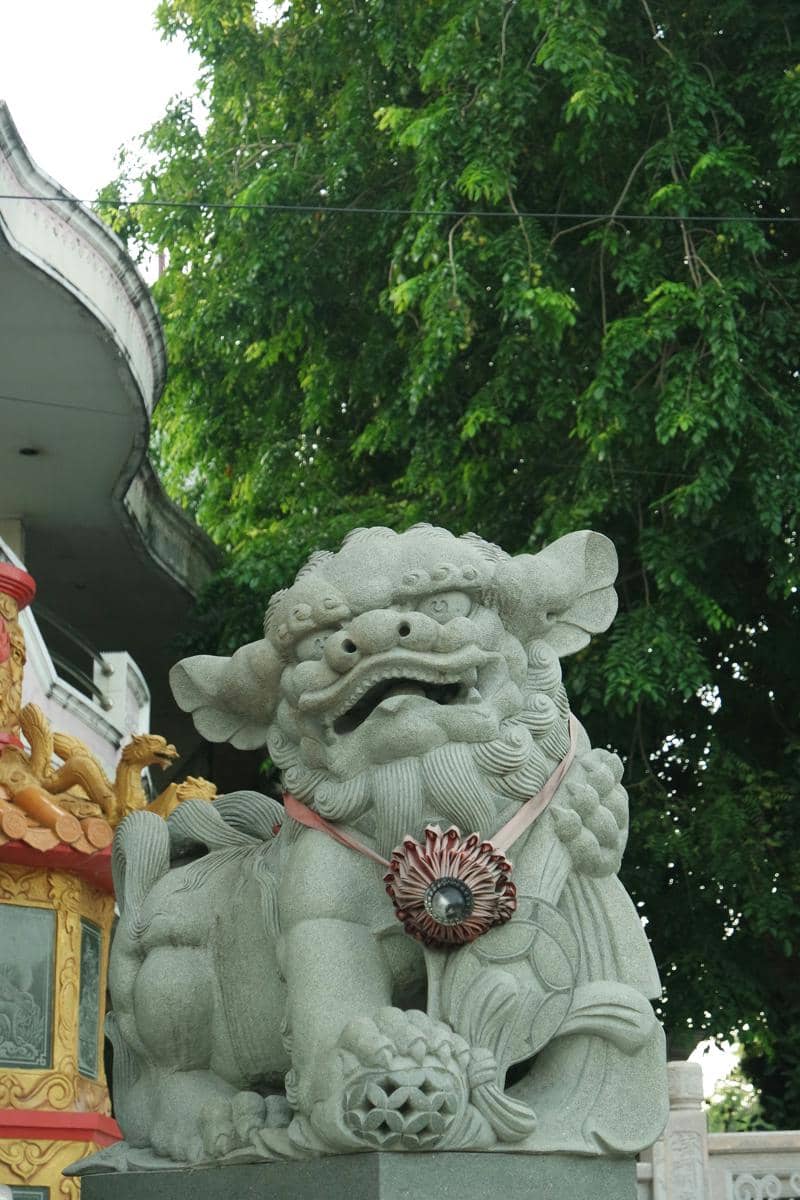a statue of a lion holding a fan in front of a building
