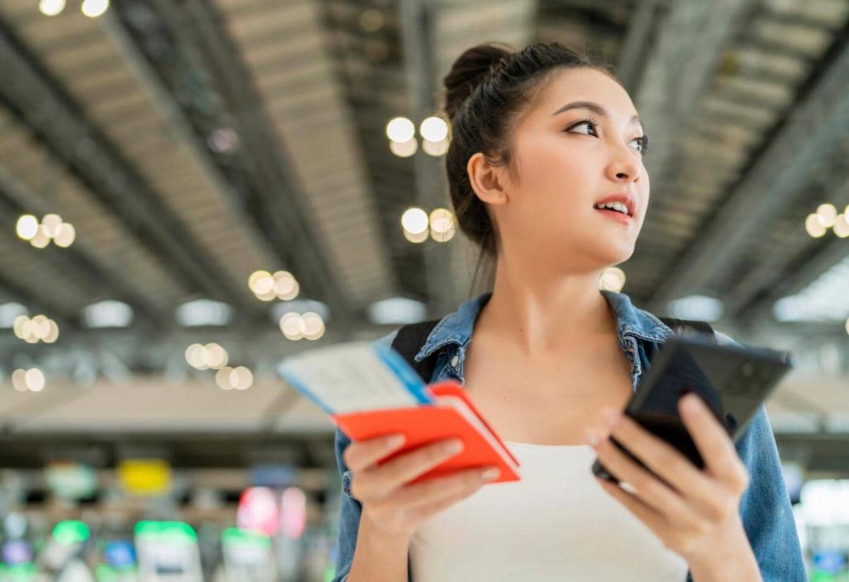 seorang traveler sedang menunggu keberangkatan di bandara