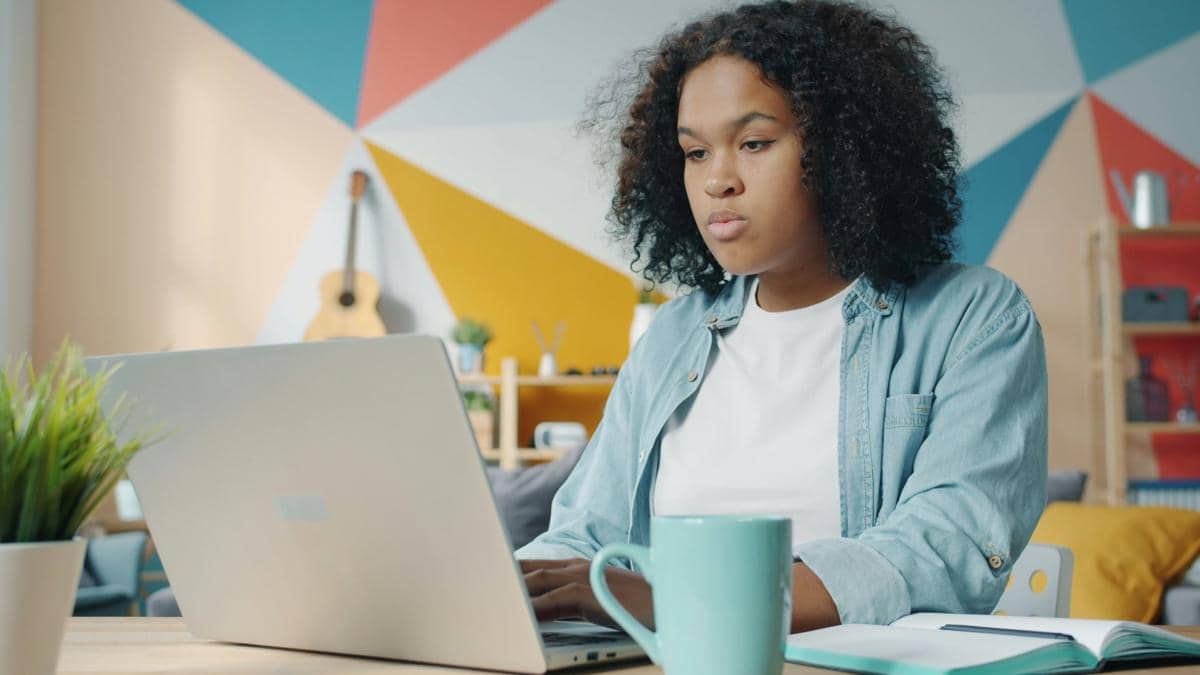 Seseorang fokus bekerja di depan laptop
